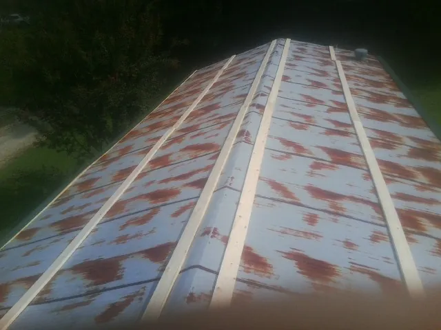 Rusted metal roof panels with new wood purlins before replacement — Storm Damage Roof Repair in Todd by Roofing Brothers