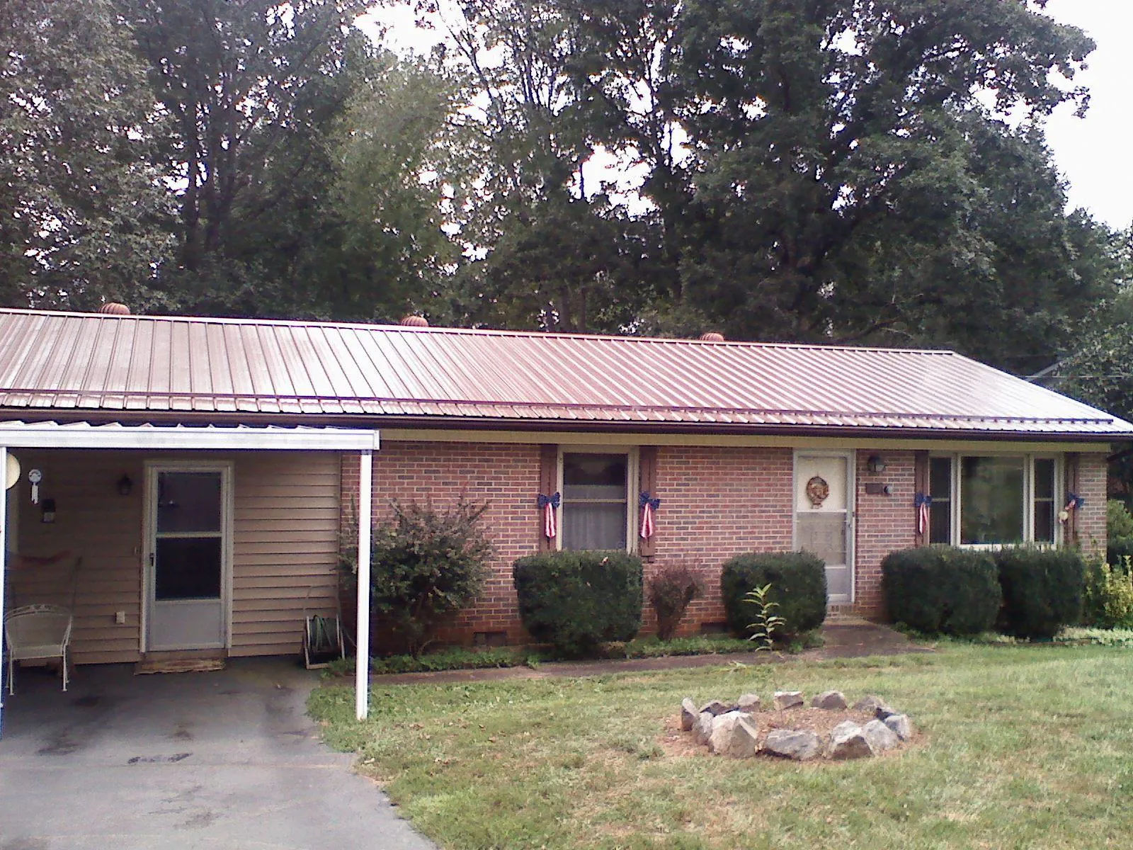 Bronze metal roof and carport on a brick ranch home — Roof Repair work by our crew in Todd